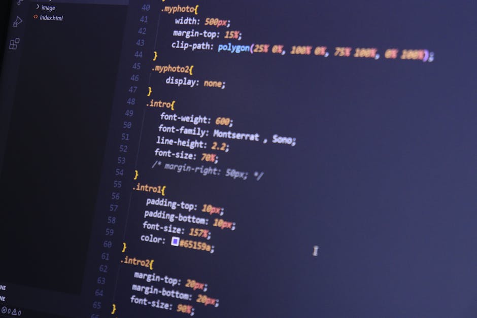 A close-up photograph of a computer screen displaying lines of colorful coding text in a dark-themed editor. The code includes CSS style definitions with properties such as width, margin-top, font-wei